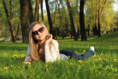  Kız parkta çim üzerinde yalan. 
