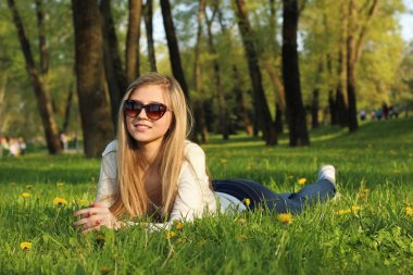  Kız parkta çim üzerinde yalan. 