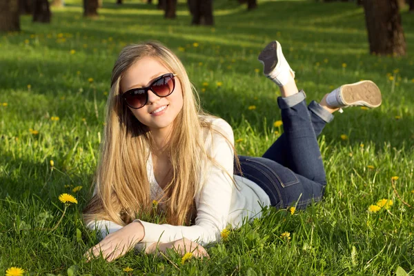  Kız parkta çim üzerinde yalan. 