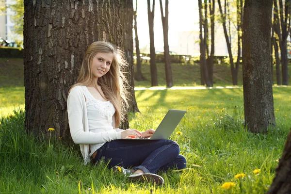 Teenage girl working with laptop in park Royalty Free Stock Photos