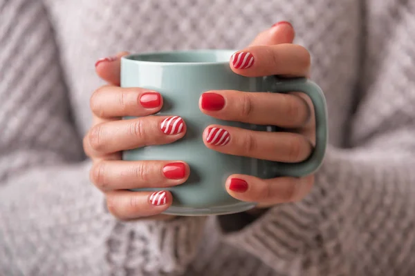 Manos de mujer sosteniendo una taza de bebida . — Foto de Stock