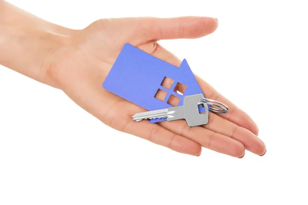 La mano sostiene la llave con un llavero la forma de la casa . — Foto de Stock