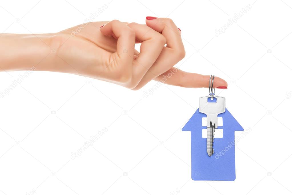 Hand holds key with a keychain the shape of house.