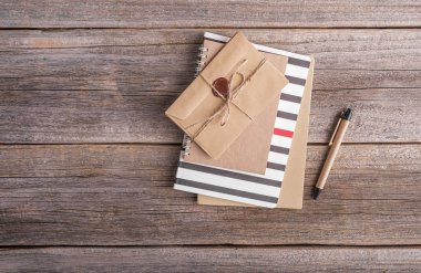 Notebook ve ahşap arka plan üzerinde zarf.
