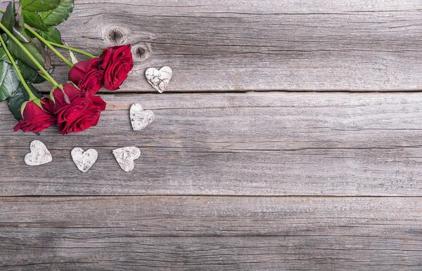 Rote Rosen und Herz auf einem hölzernen Hintergrund. — Stockfoto