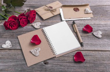 Defter ve gül ahşap arka plan üzerinde.