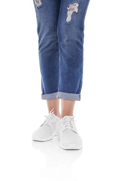 Kvinnors ben i jeans och sneakers. — Stockfoto