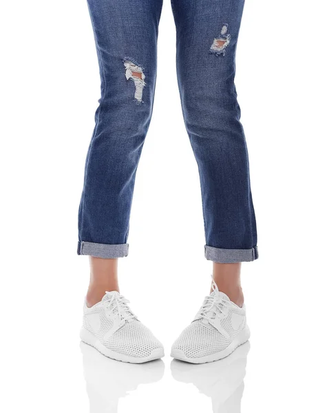 Kvinnors ben i jeans och sneakers. — Stockfoto