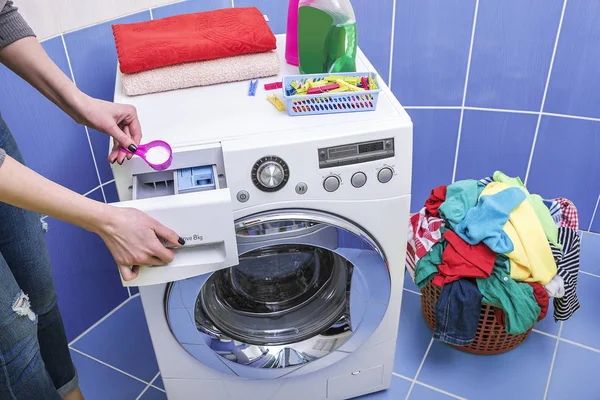 Женщина бросает стиральный порошок в стиральную машину . — стоковое фото