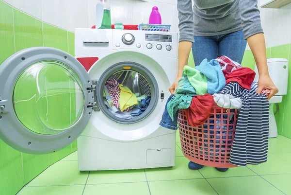 Frau hält einen Korb mit schmutziger Wäsche. — Stockfoto