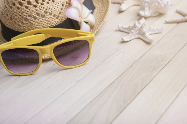 Stråhatt och solglasögon på träskivor. — Stockfoto