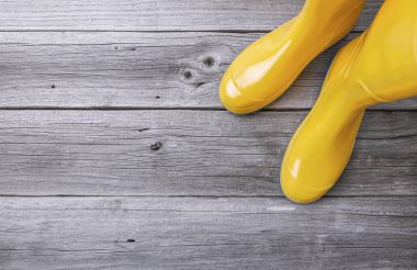 Ahşap kurullarında sarı lastik çizmeler.