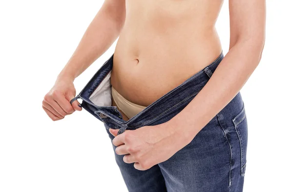 Woman shows that she has lost weight. Big jeans. — Stock Photo, Image