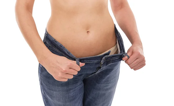 Femme montre qu'elle a perdu du poids. Gros jeans . — Photo