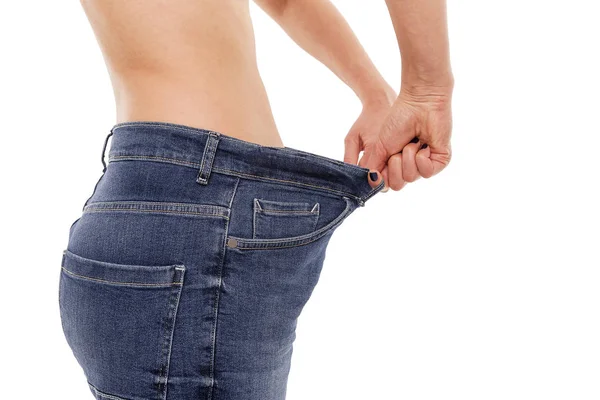 Woman shows that she has lost weight. Big jeans. — Stock Photo, Image