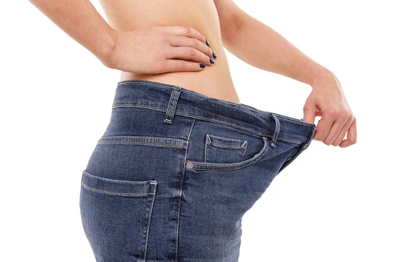 Woman shows that she has lost weight. Big jeans. — Stock Photo, Image