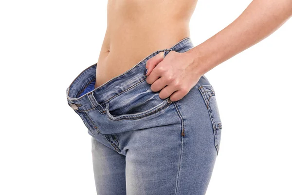 Woman shows that she has lost weight. Big jeans. — Stock Photo, Image