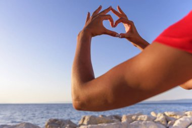 Deniz arka planı kalp şeklinde el.