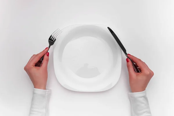 Hands with cutlery over empty plate. — Stock Photo, Image