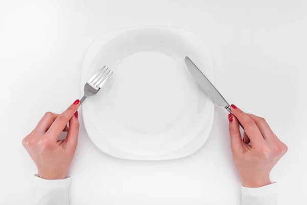 Hands with cutlery over empty plate. — Stock Photo, Image