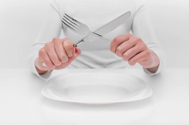 Çatal bıçak takımı boş plaka üzerinde elleriyle.