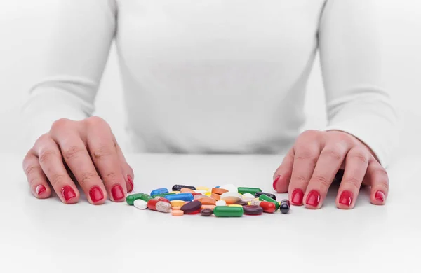 Mujer elige la medicina de un puñado de tabletas de diferentes colores . —  Fotos de Stock