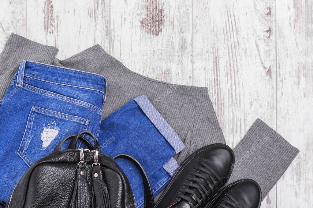 Sneakers backpack jeans and a light sweater.