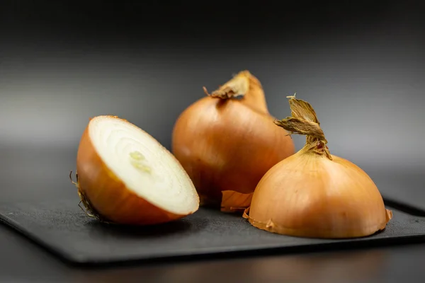 Fresh bulbs of onion on a dark background