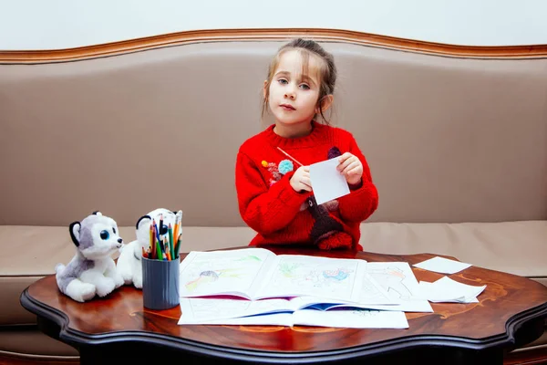 Año nuevo Navidad pensil niña escribe carta Santa chaqueta roja juguete pluma niño mesa sofá — Foto de Stock