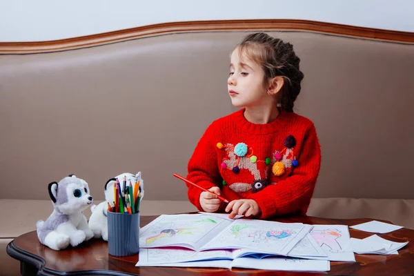 Nový rok vánoční pensil holčička píše dopis Santa červenou bundu hračka pen dítě tabulka pohovka — Stock fotografie