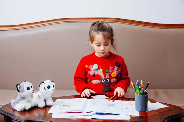 Año nuevo Navidad pensil niña escribe carta Santa chaqueta roja juguete pluma niño mesa sofá — Foto de Stock