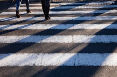 Zebra geçiş ön plan yayalar uzun gölgeler kavşak sokak ayakları kapatın