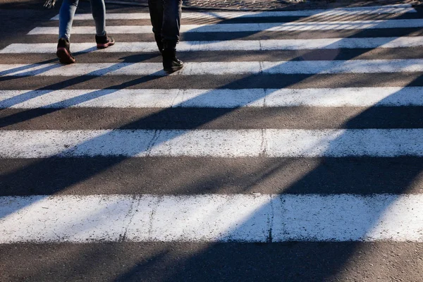 Zebra geçiş ön plan yayalar uzun gölgeler kavşak sokak ayakları kapatın — Stok fotoğraf