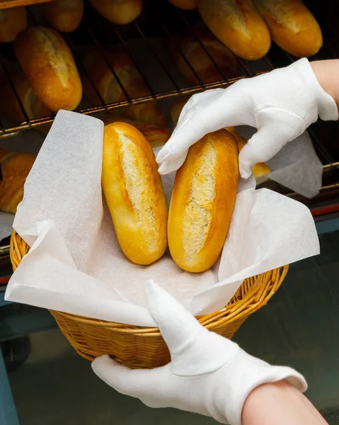 Cozimento croissant pão padeiro puxar forno fresco mão cesta fêmea amarelo laranja quente crocante doce pastelaria assar cozinhar — Fotografia de Stock
