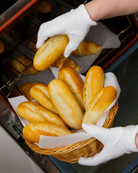 Cozimento croissant pão padeiro puxar forno fresco mão cesta fêmea amarelo laranja quente crocante doce pastelaria assar cozinhar — Fotografia de Stock