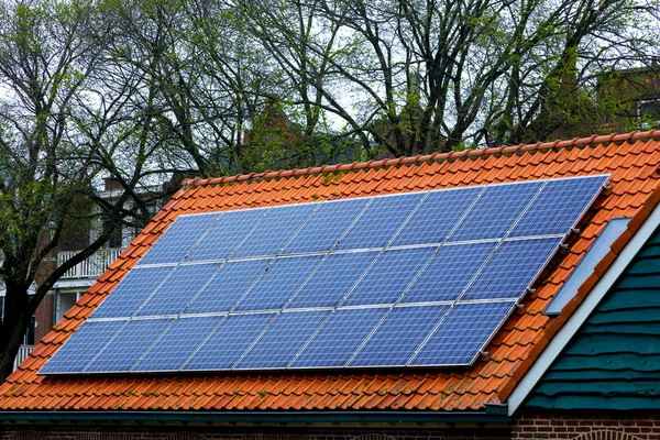Kırmızı kiremit çatı güneş panelleri ile. Eski şirketten yeni güneş teknolojileri.