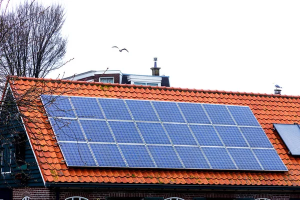 Red tile Roof with solar panels. New solar technologies on the old house.