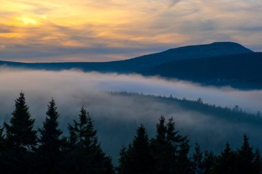 Gün batımı dağı gökyüzü mavi sonbahar güneşi açık sarı turuncu bulutlar duman sisi