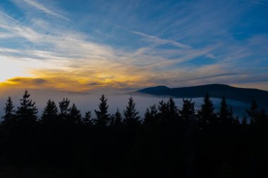 Gün batımı dağı gökyüzü mavi sonbahar güneşi açık sarı turuncu bulutlar duman sisi