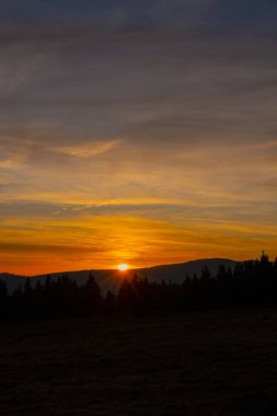 Gün batımı dağı gökyüzü mavi sonbahar güneşi açık sarı turuncu bulutlar duman sisi