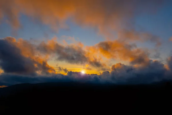 夕日山の空青いカラフルな秋の太陽の光黄色のオレンジの雲の煙霧の煙 — ストック写真