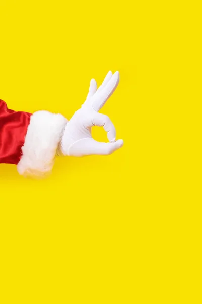 Άγιος Βασίλης γάντι χέρι κίτρινο φόντο ένα κόκκινο κοστούμι αντίγραφο χώρου — Φωτογραφία Αρχείου