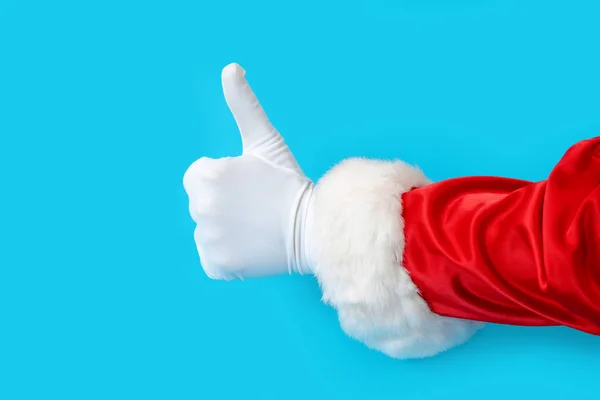 Άγιος Βασίλης γάντι χέρι μπλε φόντο ένα κόκκινο κοστούμι αντίγραφο χώρου — Φωτογραφία Αρχείου
