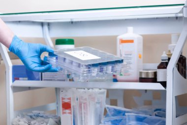 Virüs analizinin hazırlanması. Mavi eldivenli eller test için tüpleri tutuyor..