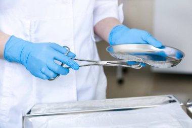 Eller doktor ameliyattan önce cımbız ve tampon tutun. Cerrahî donanımlar işlem sırasında kullanılan