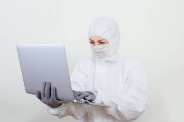 Koruyucu takım elbiseli ve yüz maskesi takan kadın doktor internet üzerinden. Beyaz arka planda not defteri olan sağlık görevlisi kadın..