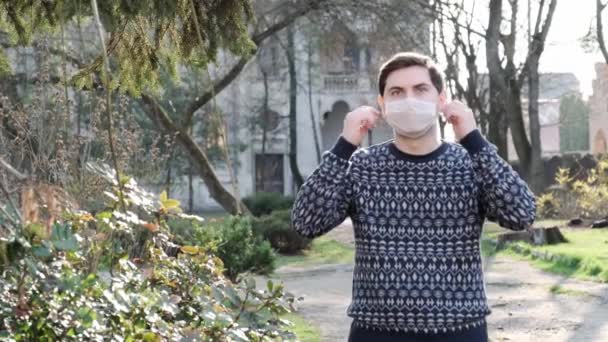 在恐慌时期 一个戴着白色医疗面具的年轻人出现在街上 盖伊摘下面具 — 图库视频影像