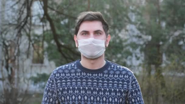 Máscara médica blanco calle hombre joven coronavirus covid 19 ojos azules — Vídeos de Stock