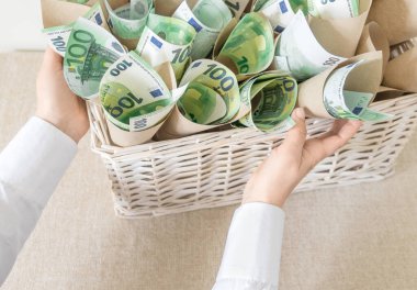 Beyaz Arkaplanda Bir Hediye Olarak Beyaz Wisker Sepeti 'nde Bir sürü fatura 100 Euro. Parayla Hediye Paketi Tutar.