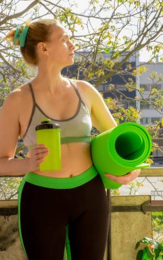 Evinin balkonunda yeşil bir yoga minderi olan güzel bir Orta Çağ Kadını, Gerçek Portre.